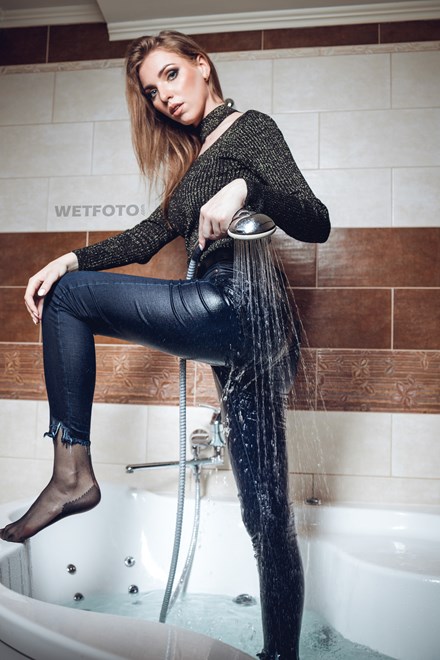 wetfoto beautiful girl takes bath shower fully clothed
