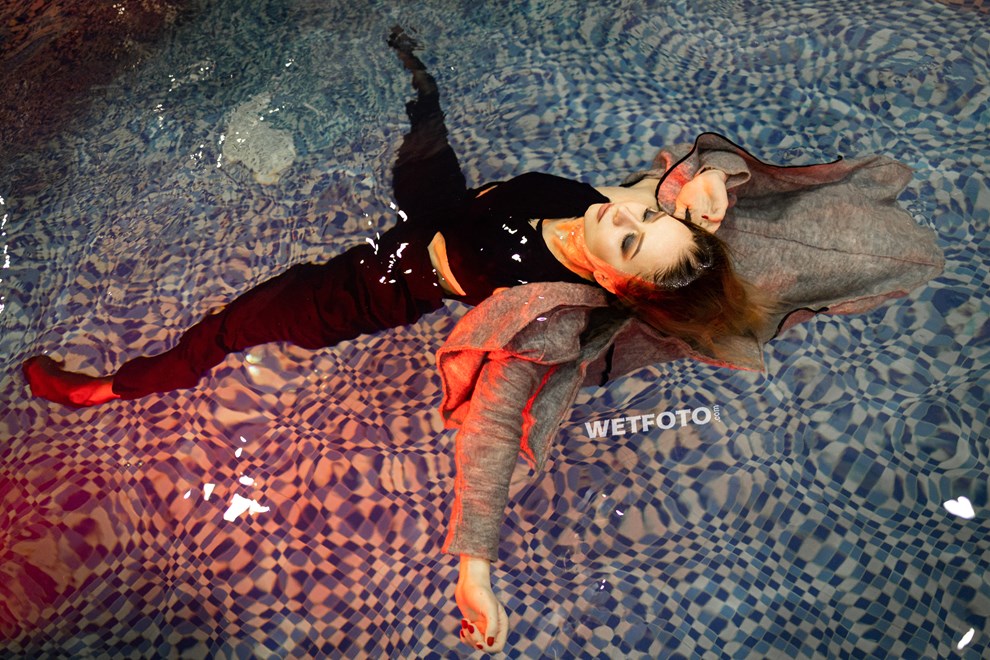 wetfoto woman swims pool fully clothed winter coat